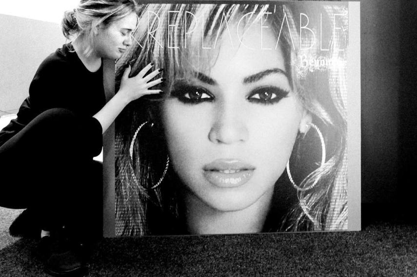Adele posa com pôster de Beyoncé