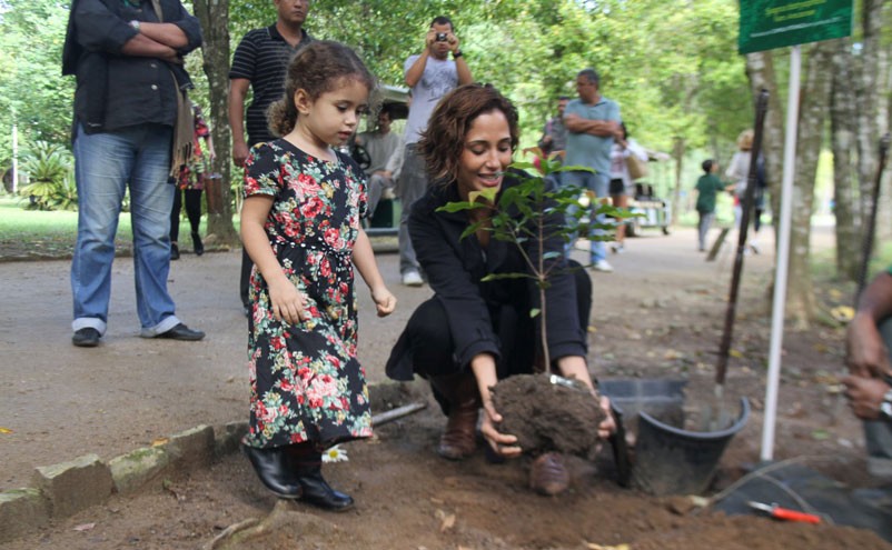 Camila Pitanga planta um cravo da índia ao lado da filha Antonia