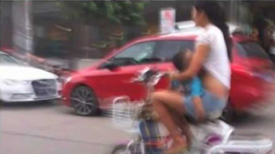 Mulher é flagrada amamentando bebê enquanto guia moto