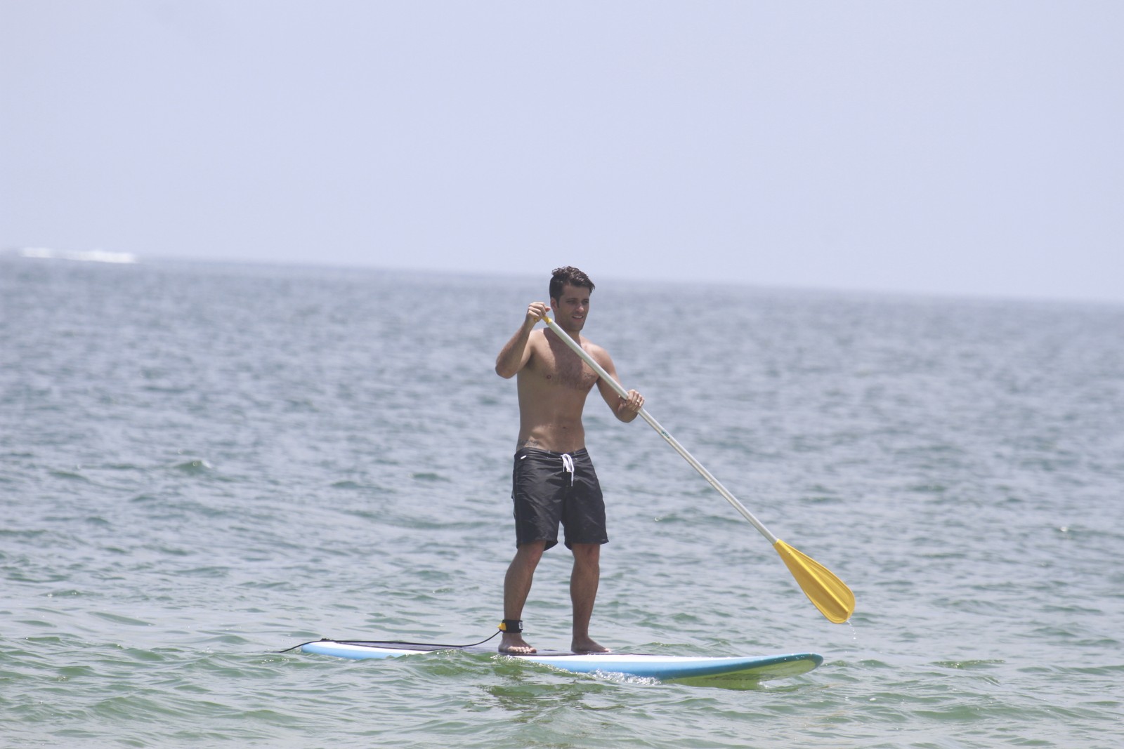 Bruno Gagliasso vai à praia com Giovanna Ewbank e pratica stand up paddle