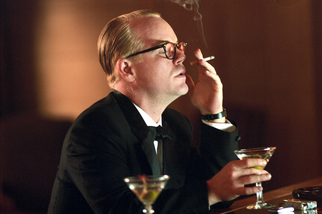 Como o escritor Truman Capote, no filme Capote. O papel que lhe rendeu o Oscar de melhor ator em 2005
