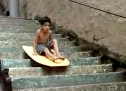 Menininho tem a ideia genial de surfar escadaria abaixo em favela; assista!
