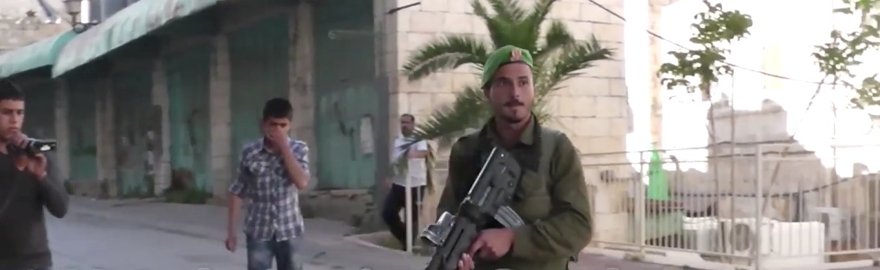 Soldado israelense aponta arma para menino palestino