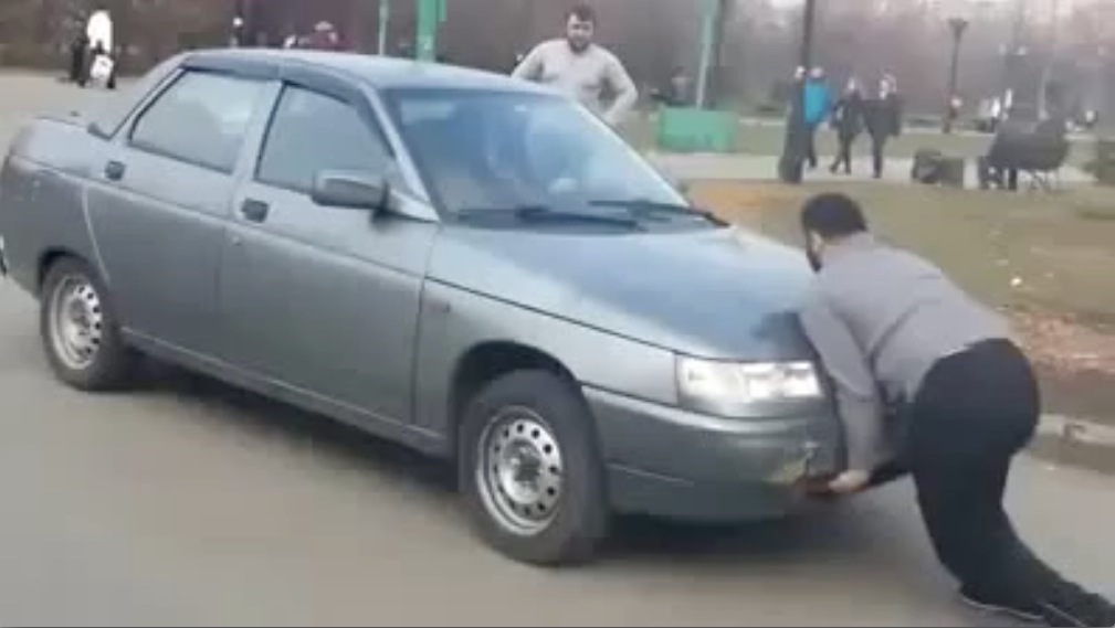Homem durão segura carro em aceleração usando apenas as mãos