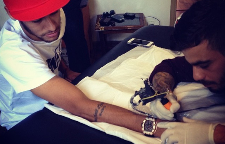 Neymar tatua a palavra “fé” no braço