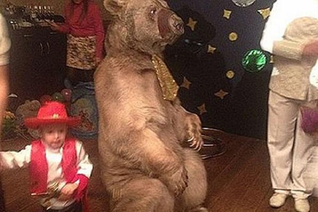 Urso usando gravata ao lado do filho de Kombarov, jogador russo