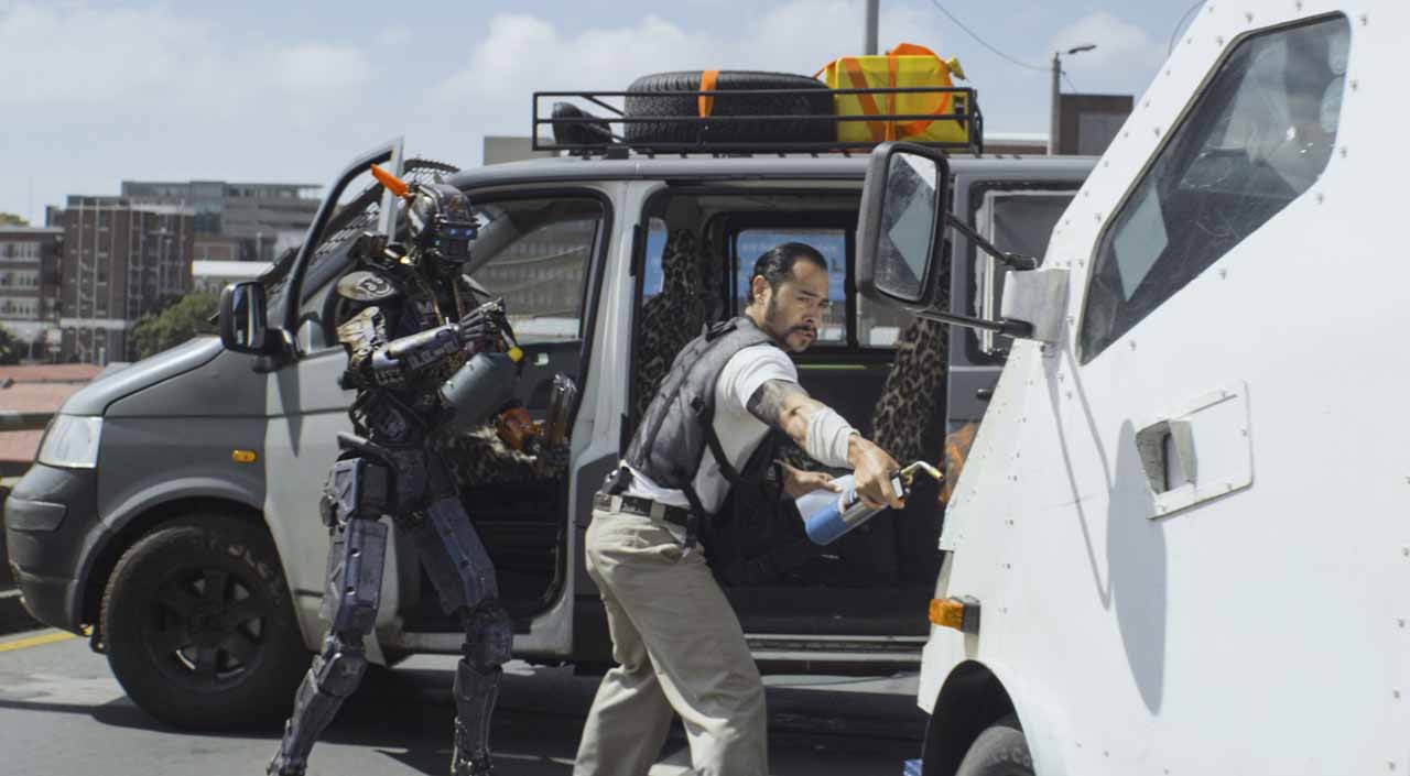 Cena do filme Chappie, com Sharlto Copley, Dev Patel, Jose Pablo Cantillo, Sigourney Weaver e Hugh Jackman
