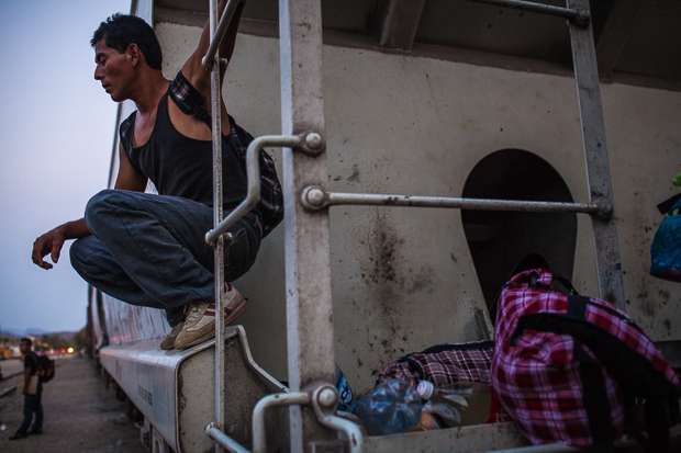 Migrante hondurenho espera um trem na estação