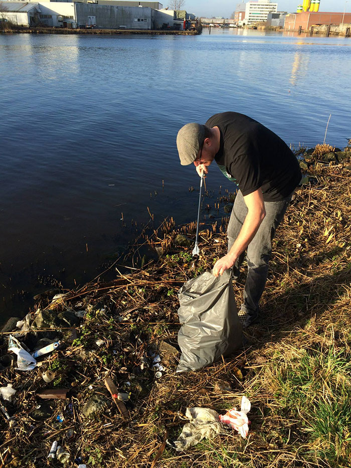 Tommy Klein catando lixo do rio: um saco por dia