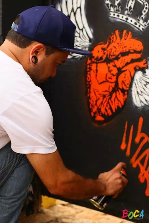 <b>Idade</b>: 30 anos
<b>Cidade</b>: Poá (SP) 

<b>Bio</b>: Formado em Artes e professor de artes na rede estadual de ensino de São Paulo. Começou a fazer sua arte nos muros da cidade onde mora, Poá, em 2012. No mesmo ano levou sua arte para o centro de São Paulo. Muros e bancas de jornais pelo centro são suas telas, além de pintar em eventos comunitários em comunidades e periferia. As técnicas usadas são stencil cortado à mão e spray.