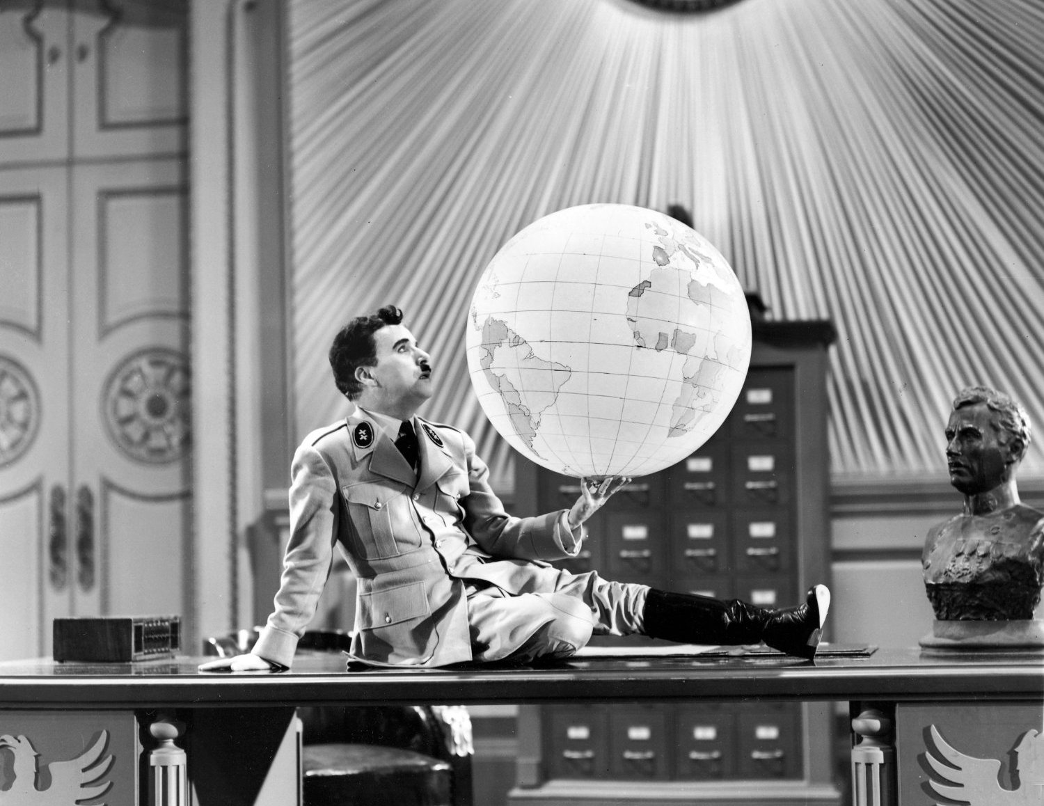 Apesar de não se passar oficialmente na Segunda Guerra, o personagem que dá nome ao filme é claramente uma alusão a Adolf Hitler.
Um clássico inquestionável do cinema, essa obra-prima de 1940 escrita, dirigida e estrelada por Charles Chaplin conta a história de um barbeiro judeu que é confundido com o ditador alemão Adenoyd Hynkel, e acaba envolvido em situações inesperadas. E desse longa a cena icônica de Chaplin brincando com um globo terrestre.