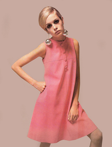A modelo Twiggy fez da sua marca registrada nos anos 60 os vestidos trapézios. Ela combinava a peça com maxibrincos e sapatos de pegada boyish 