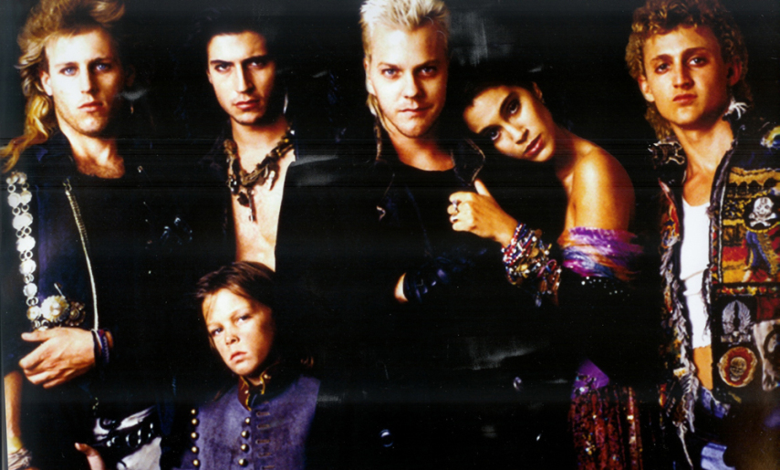 Na linha pop-HQ de A Hora do Espanto, este filme marcou a geração 80. Um bando de vampiros juvenis (góticos-darks-punks-roqueiros) morde o jovem protagonista (Jason Patrick em look Jim Morrison), e o irmão caçula dele tenta destruir a gangue