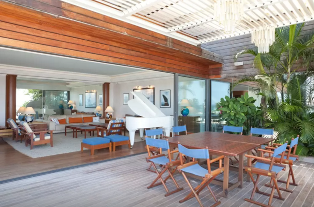 Um piano branco de cauda impressiona quem chega na sala. Incrível, não?!
