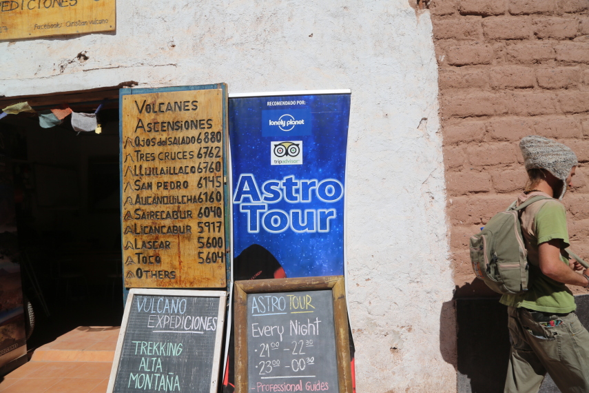 San Pedro de Atacama: as agências oferecem passeios, como o tour astronômico durante a noite, e também turismo de aventura com a escalada de vulcões. Na placa de madeira, dá pra ver a altura de alguns deles. Tem coragem?