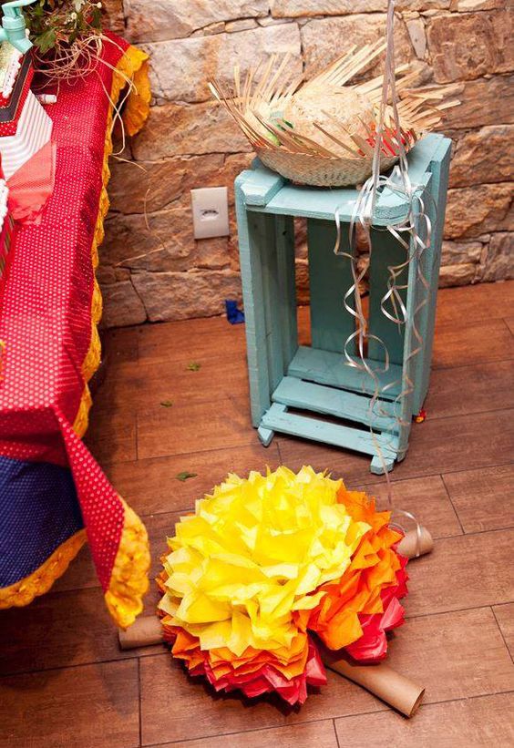 Uma caixa de feira pode ser usada para compor seu ambiente caipira. Sem contar que festa junina boa é com fogueira, como essa que foi feita usando papel crepe e rolos de papel higiênico ou papel toalha 