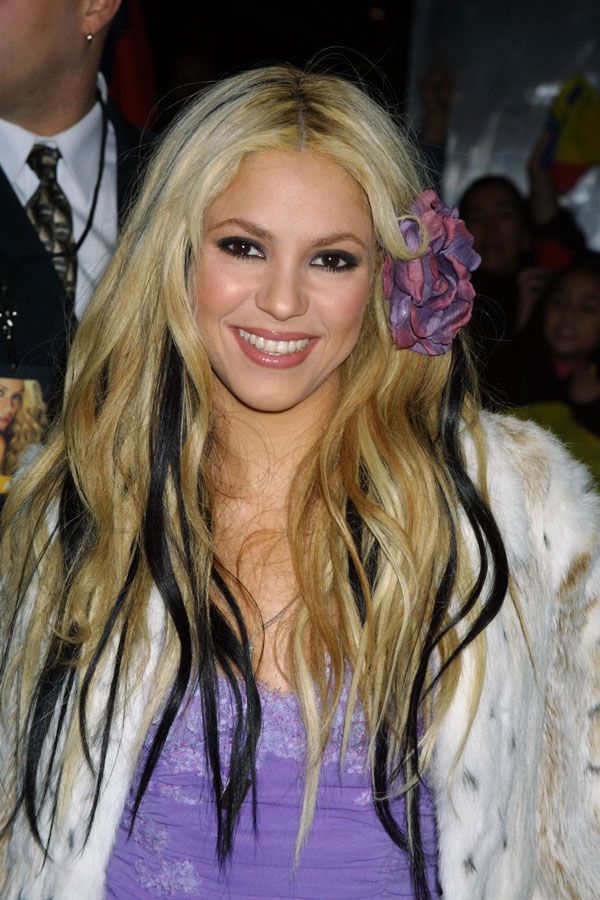 Em 2001, Shakira no Emmy com faixas pretas finas mescladas com o cabelão loiro