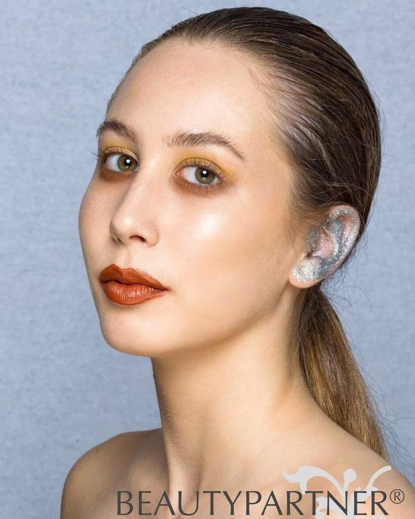 De acordo com a revista Marie Claire, o designer Anthony Vaccarello deu o pontapé no uso de maquiagem nas orelhas de suas modelos em 2014, assim como maquiador Tom Pecheux já vinha criando adornos brilhantes que lembravam joias nas mulheres. Desde então, essa opção de usar as orelhas para brincar com desenhos como bolinhas ou faixas brilhantes tem estimulado alguns artistas populares no instagram, como a maquiadora Violette (@violette_fr). São desenhos prateados, dourados ou até foscos brincando com os contornos das orelhas ou apostando em formas geométricas.