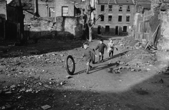Crianças brincam em área atingida por bomba em Londres, no dia 9 de março de 1946