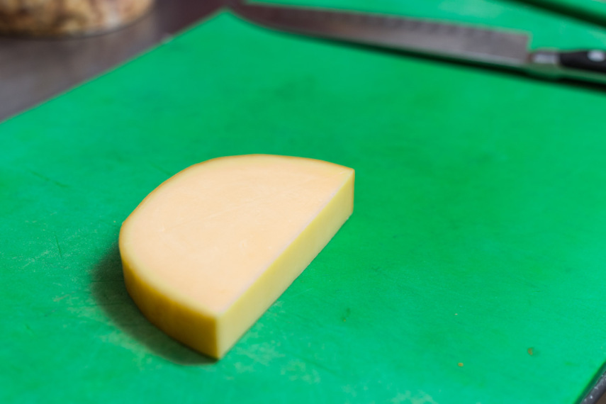 Geralmente, o provolone vem em um corte redondo. Corte a peça na metade