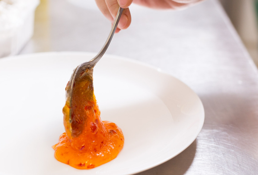 Em um prato, coloque um pouco de geleia de pimenta, a peça de parmesão e duas fatias de pão italiano. Coloque folhas de majericão roxo para enfeitar e dar perfume ao prato