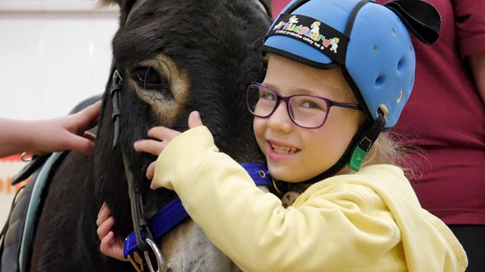 Amizade com burro ajuda menina a desenvolver fala e músculos