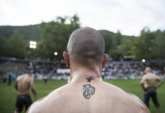 Em festival, atletas lutam com corpo coberto de azeite de oliva para homenagear apóstolos