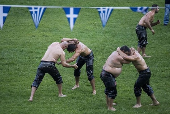 Em festival, atletas lutam com corpo coberto de azeite de oliva para homenagear apóstolos