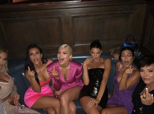 Irmãs Kardashian apostam em looks ousados para festa. Kim e Kylie trazem releitura hot do já batido vestido com recorte abaixo do decote. Será que a moda pega?