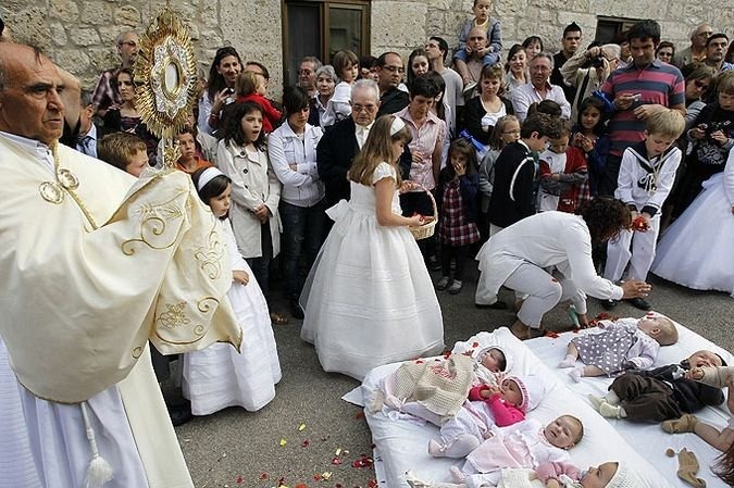 Depois do salto, crianças são abençoadas por um padre e se comemora jogando pétalas sobre os bebês.