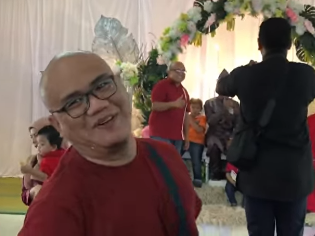 Azly Yozof se surpreendeu ao encontrar um convidado extremamente parecido com ele durante o casamento de um amigo de infância. Surpreendentemente, o homem também vestia uma camisa vermelha, jeans e óculos!