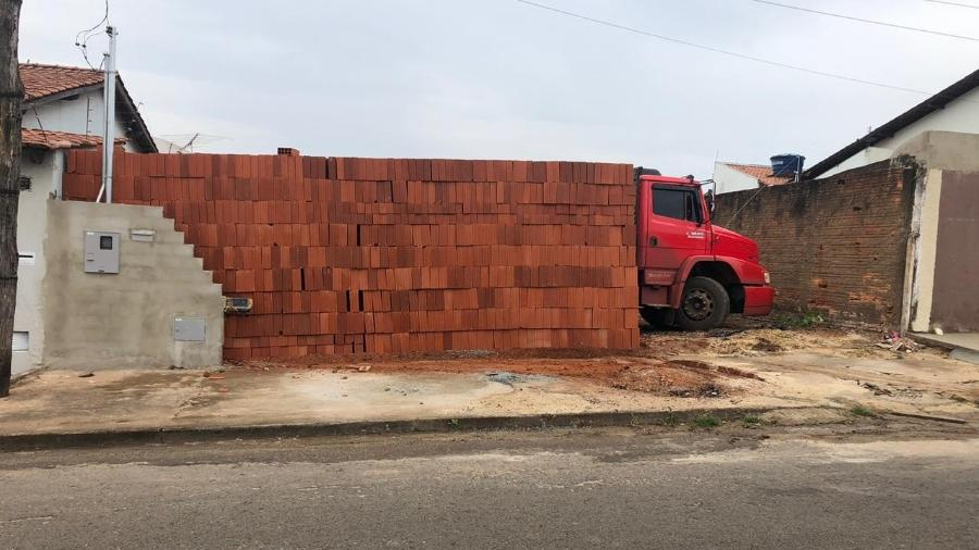 Homens descarregam 5 mil tijolos, mas caminhão fica preso dentro do terreno